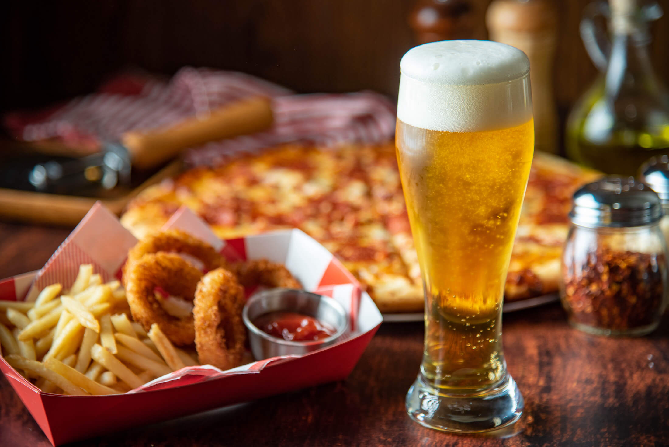 Beer, onion rings, fries, and pizza