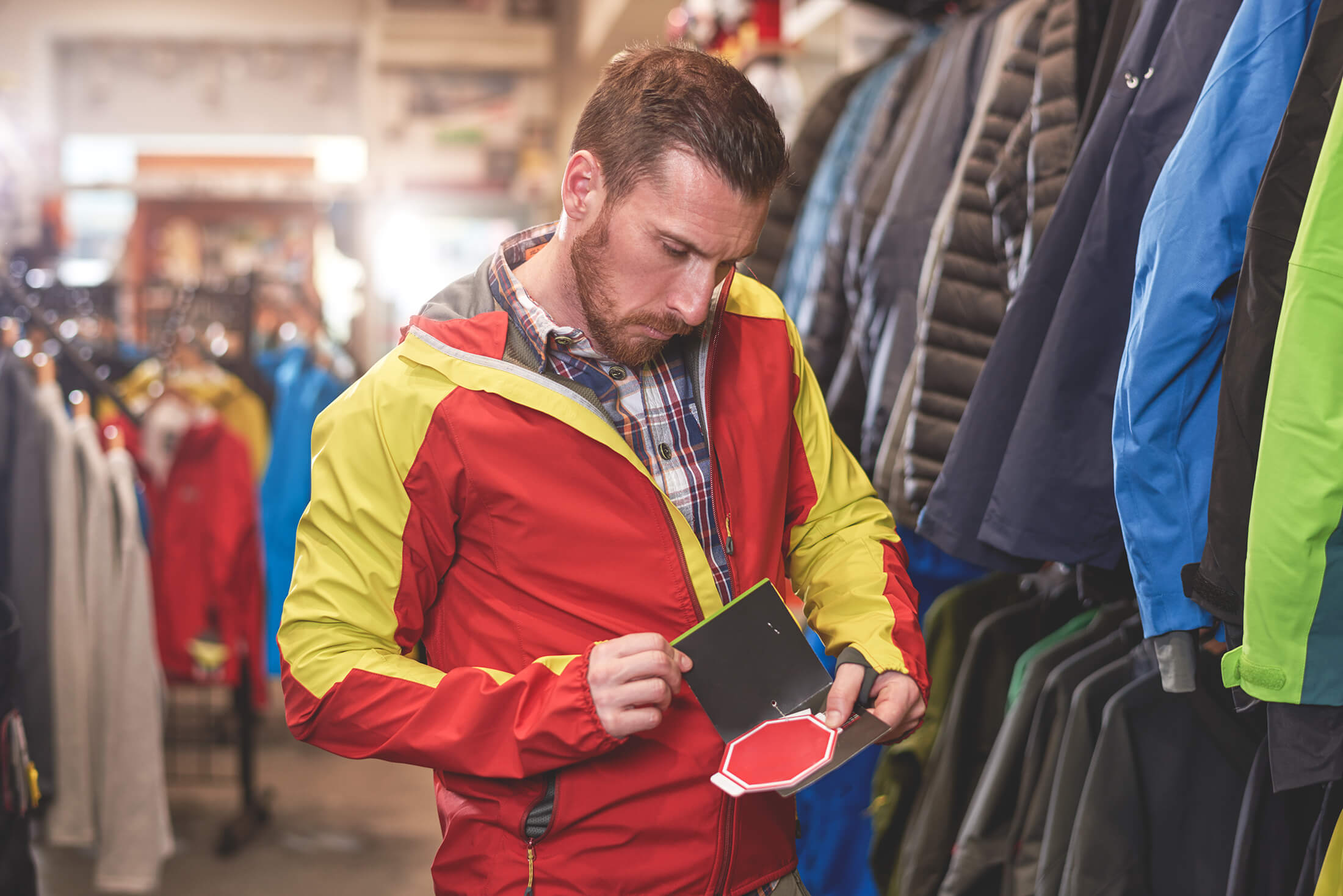 Men trying on a jacket and looking at tag